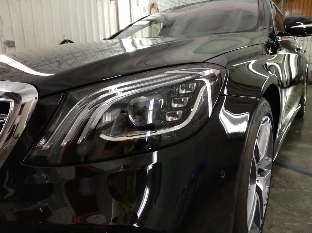 Poleeritud auto esituli ja kapott pärast detailingut